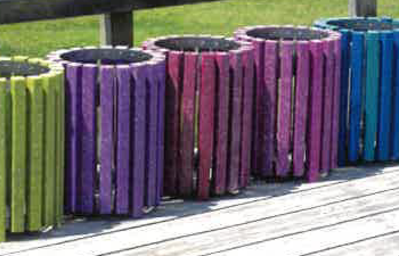 Papeleras de colores en terraza de madera